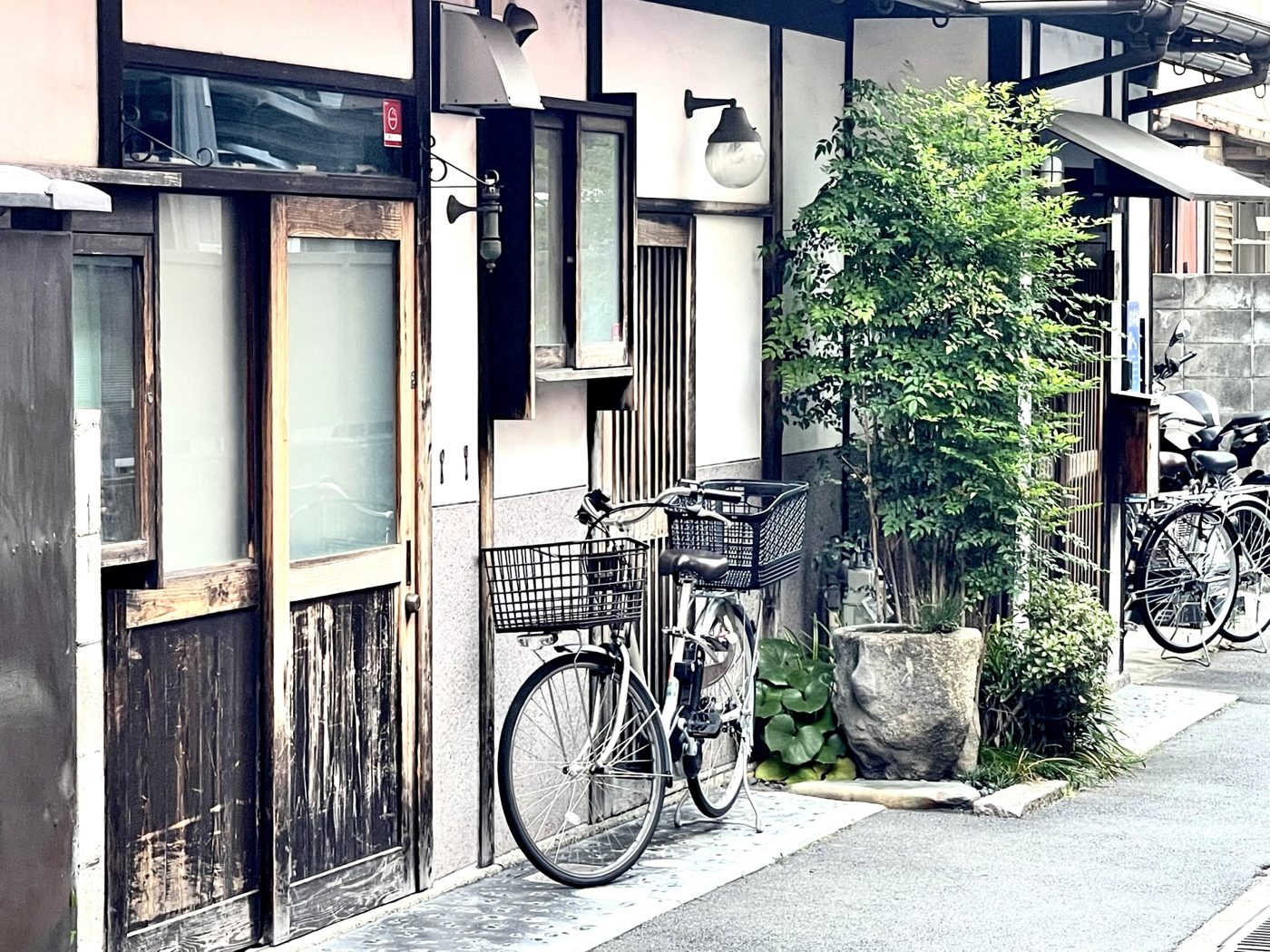 自転車が置かれた、木造住宅の間の細い路地