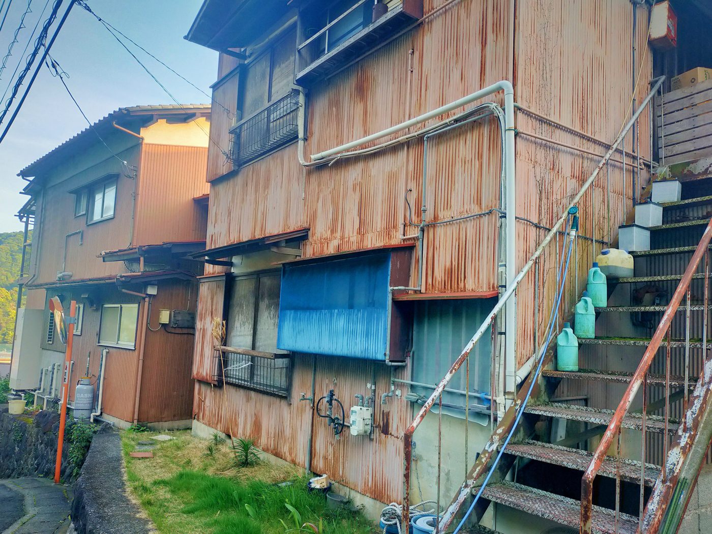 トタン外壁がさびた古い木造アパートの外階段