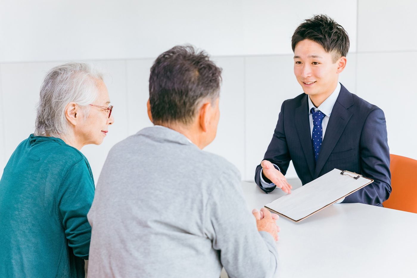 書類を手に高齢のご夫婦に説明する男性の担当者