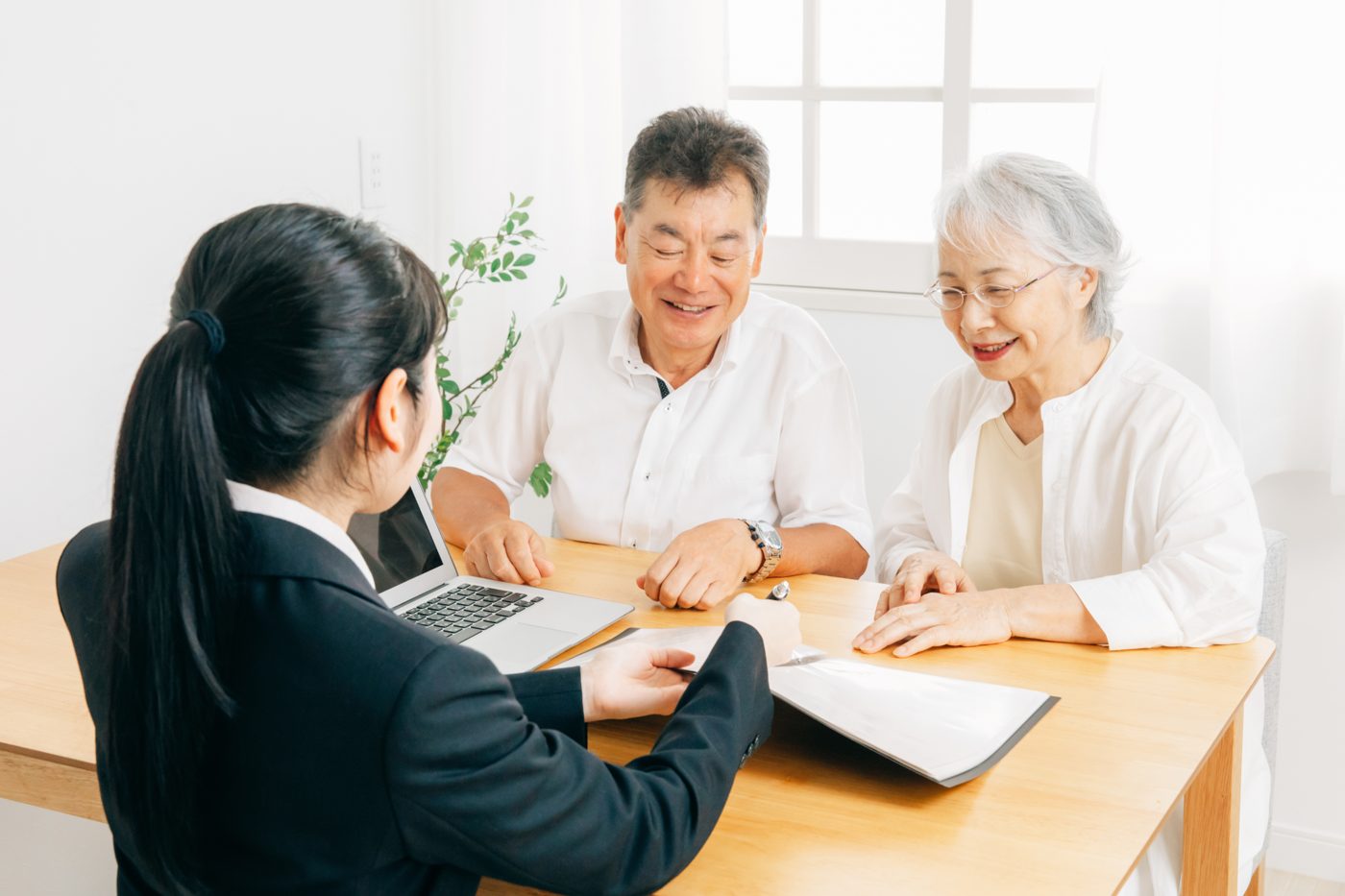 書類を手に高齢のご夫婦へ説明する担当者