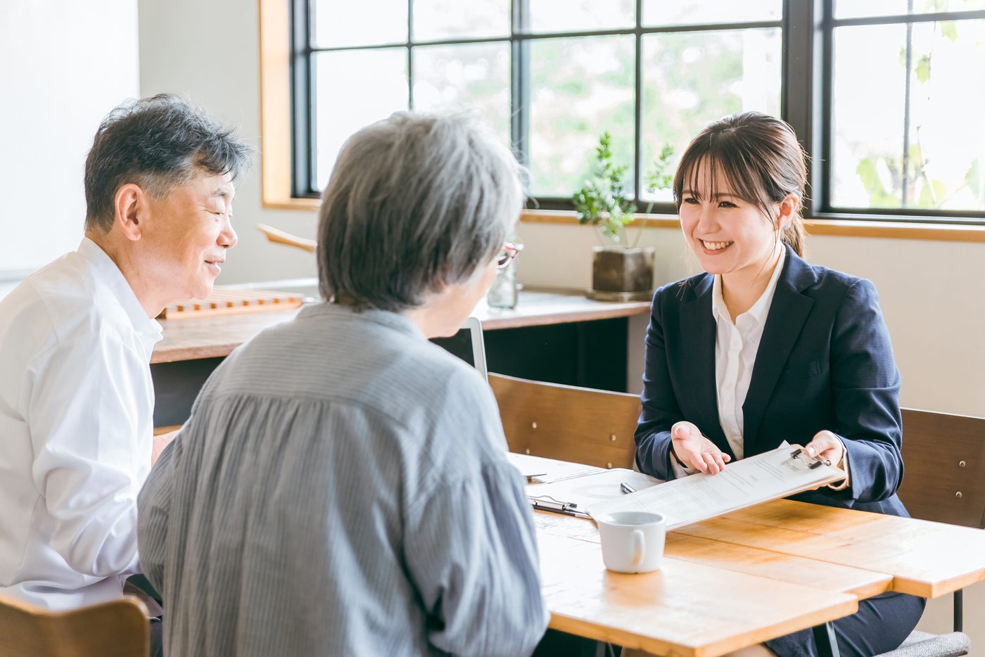 窓際の席で担当者と話す高齢のご夫婦